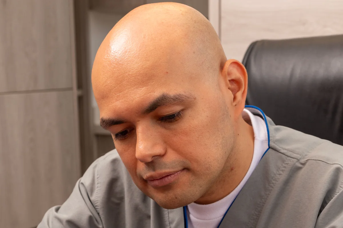 Dr. Daniel Amaya revisando el historial clínico de un paciente durante la consulta de alergología